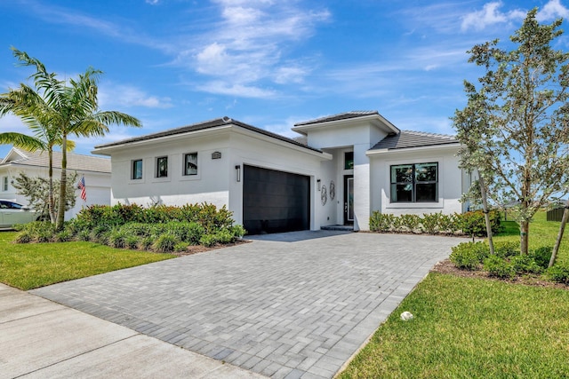 17135 SW Ambrose Way, Port Saint Lucie, FL 34986 - view of front facade featuring decorative driveway, an attached garage, stucco siding, a front lawn, and a tile roof