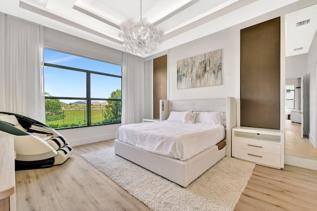 17135 SW Ambrose Way, Port Saint Lucie, FL 34986 - bedroom featuring a tray ceiling, a chandelier, light wood finished floors, and baseboards