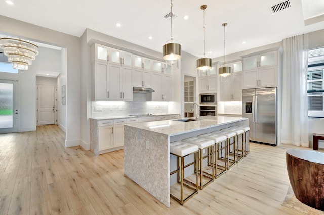 17135 SW Ambrose Way, Port Saint Lucie, FL 34986 - kitchen featuring stainless steel appliances, a center island with sink, backsplash, white cabinets, and recessed lighting