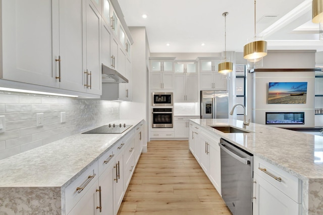 17135 SW Ambrose Way, Port Saint Lucie, FL 34986 - kitchen featuring a sink, black appliances, under cabinet range hood, light wood finished floors, and a spacious island