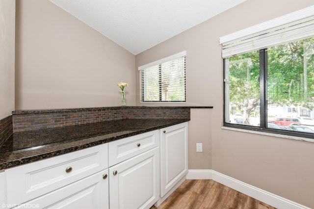 805 Harbour Pointe Way, Greenacres, FL 33413 - kitchen featuring vaulted ceiling, tasteful backsplash, light wood-style floors, white cabinets, and baseboards