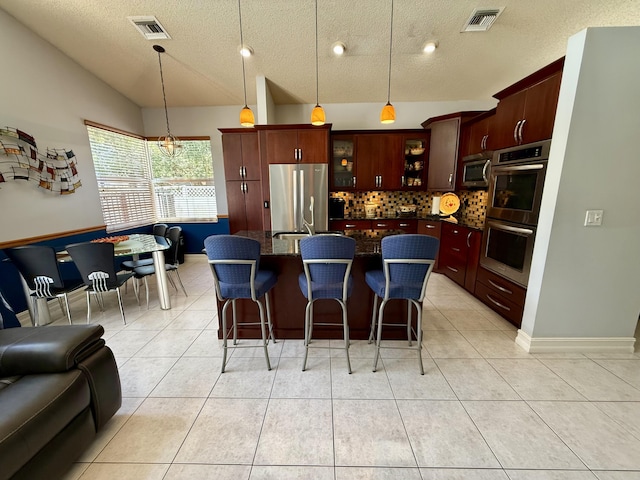 7906 Rockport Cir, Lake Worth, FL 33467 - kitchen featuring stainless steel appliances, lofted ceiling, a textured ceiling, decorative backsplash, and light tile patterned floors