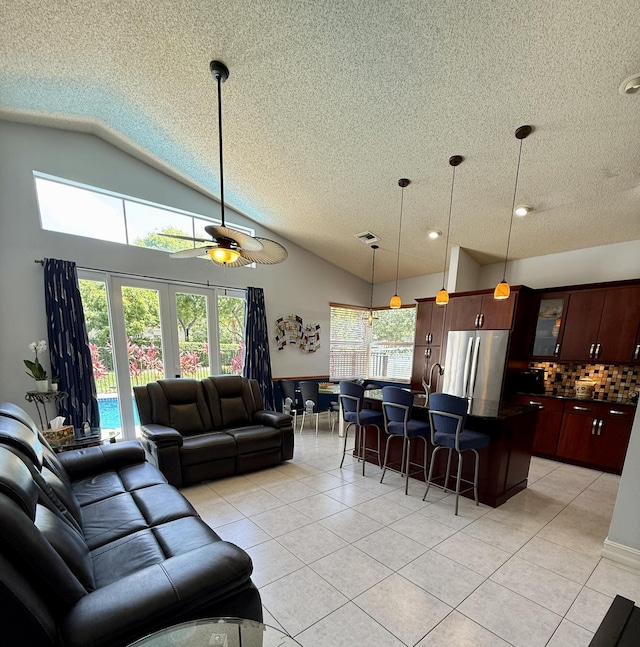 7906 Rockport Cir, Lake Worth, FL 33467 - living room featuring a textured ceiling, lofted ceiling, light tile patterned flooring, and ceiling fan
