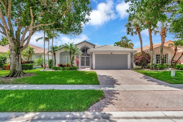 7566 San Pedro St, Boynton Beach, FL 33437 - view of front of home with stucco siding, a garage, decorative driveway, a tiled roof, and a front yard