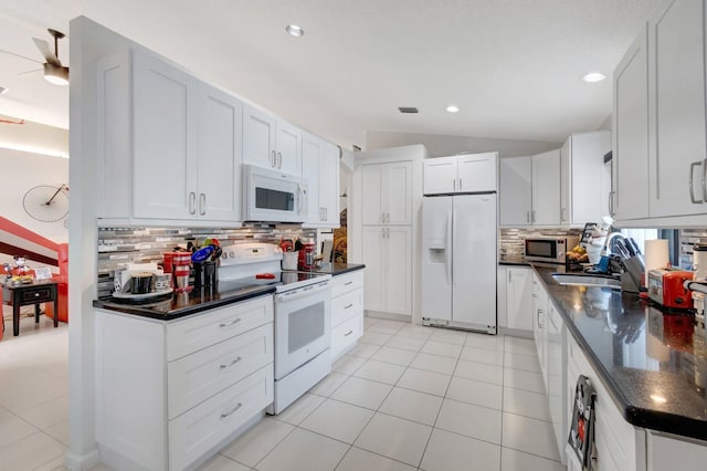 7566 San Pedro St, Boynton Beach, FL 33437 - kitchen featuring white appliances, dark countertops, tasteful backsplash, light tile patterned floors, and vaulted ceiling