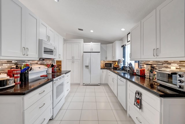 7566 San Pedro St, Boynton Beach, FL 33437 - kitchen with white appliances, a sink, tasteful backsplash, vaulted ceiling, and light tile patterned floors