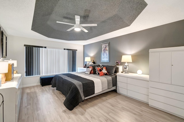 7566 San Pedro St, Boynton Beach, FL 33437 - bedroom featuring light wood-type flooring, a textured ceiling, a raised ceiling, a ceiling fan, and baseboards