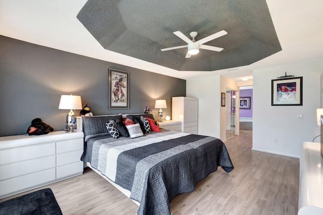 7566 San Pedro St, Boynton Beach, FL 33437 - bedroom featuring a raised ceiling, light wood-style flooring, and a ceiling fan