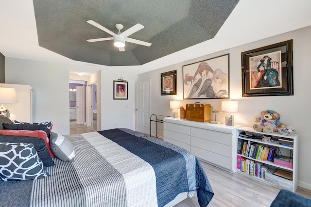 7566 San Pedro St, Boynton Beach, FL 33437 - bedroom featuring light wood-style flooring, a raised ceiling, ensuite bathroom, and a ceiling fan