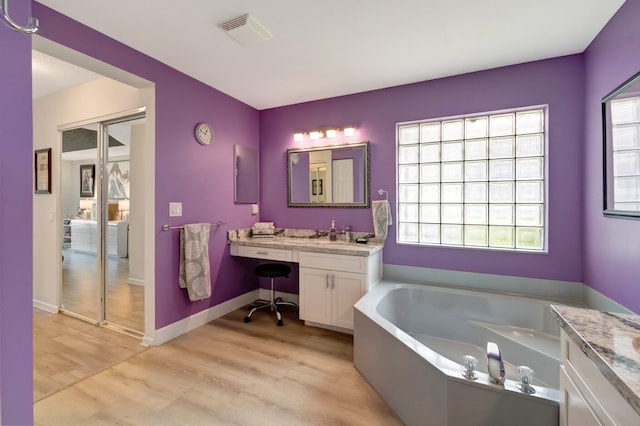 7566 San Pedro St, Boynton Beach, FL 33437 - bathroom with a bath, wood finished floors, vanity, and baseboards