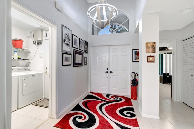 7566 San Pedro St, Boynton Beach, FL 33437 - entryway with washing machine and dryer, a chandelier, baseboards, and light tile patterned flooring