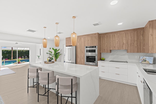 812 Chapel Hill Blvd, Boynton Beach, FL 33435 - kitchen with stainless steel appliances, modern cabinets, a kitchen island, a breakfast bar area, and recessed lighting