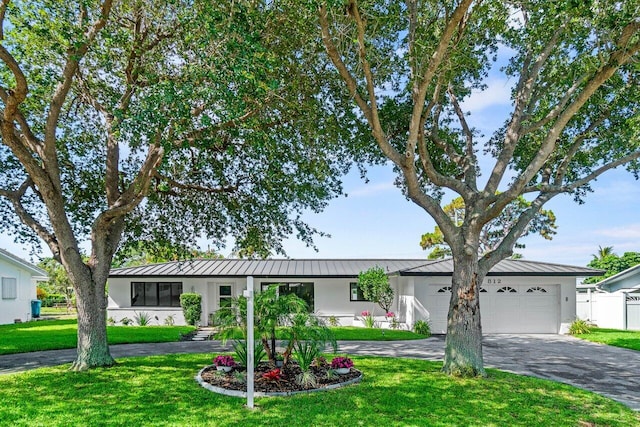 812 Chapel Hill Blvd, Boynton Beach, FL 33435 - ranch-style house featuring a standing seam roof, a garage, stucco siding, and asphalt driveway