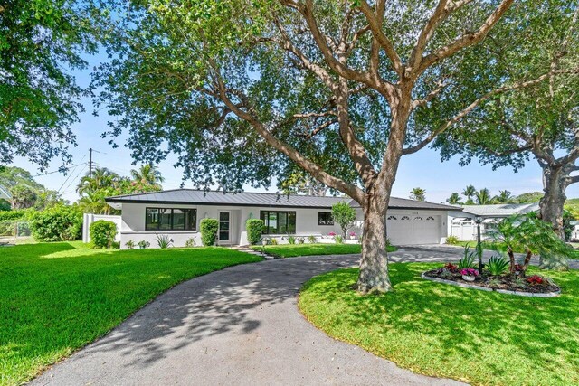 812 Chapel Hill Blvd, Boynton Beach, FL 33435 - ranch-style house featuring stucco siding, curved driveway, a garage, and metal roof