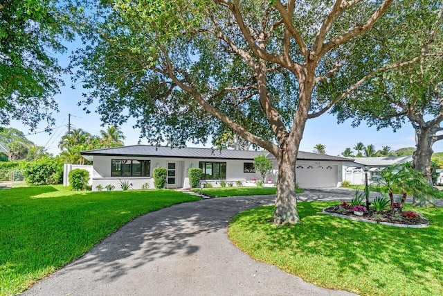 812 Chapel Hill Blvd, Boynton Beach, FL 33435 - ranch-style house featuring stucco siding, curved driveway, an attached garage, a metal roof, and a standing seam roof