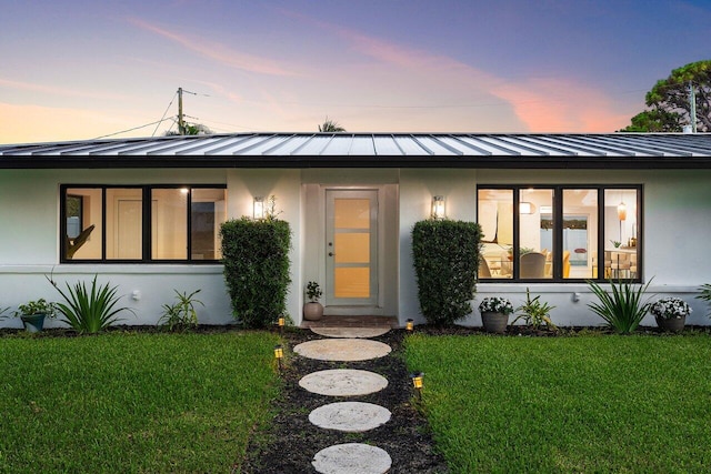 812 Chapel Hill Blvd, Boynton Beach, FL 33435 - view of front facade with a standing seam roof, a lawn, a metal roof, and stucco siding