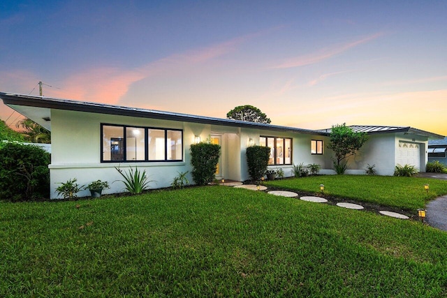 812 Chapel Hill Blvd, Boynton Beach, FL 33435 - view of front of home featuring an attached garage, a front lawn, stucco siding, a standing seam roof, and a metal roof