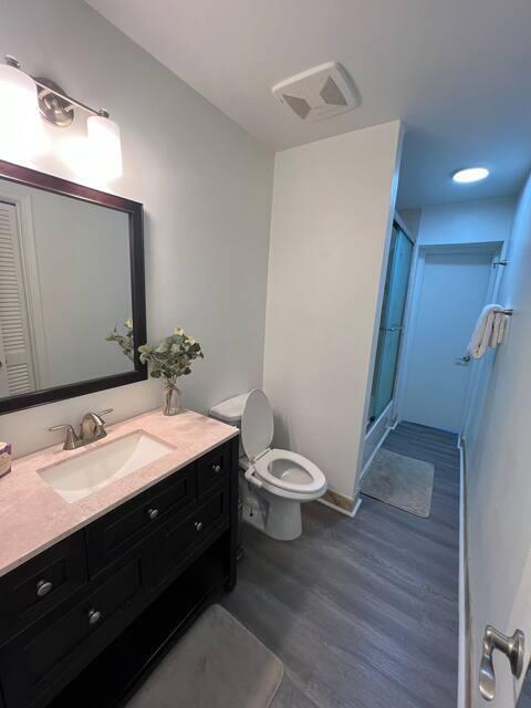 2809 SW 46th St, Dania Beach, FL 33312 - full bathroom featuring wood finished floors, a stall shower, toilet, and vanity