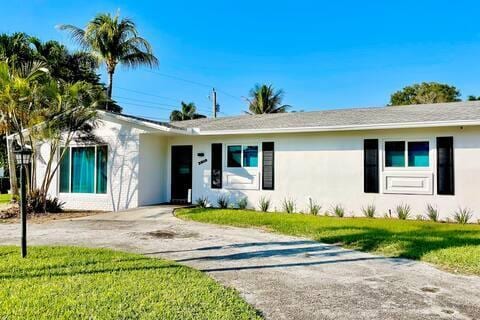 2809 SW 46th St, Dania Beach, FL 33312 - ranch-style house featuring stucco siding, a front lawn, and concrete driveway
