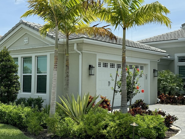 4662 Estates Cir, Westlake, FL 33470 - view of side of property with a garage, stucco siding, driveway, and a tiled roof