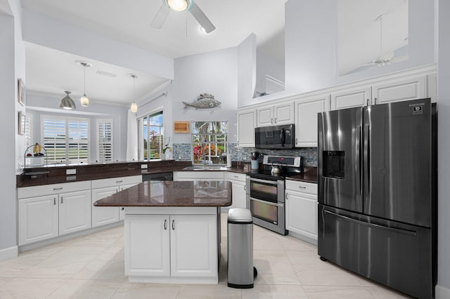 550 SW Sanctuary Dr, Port Saint Lucie, FL 34986 - kitchen with stainless steel appliances, a ceiling fan, white cabinetry, decorative backsplash, and crown molding