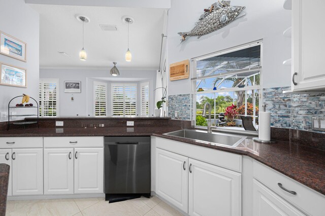 550 SW Sanctuary Dr, Port Saint Lucie, FL 34986 - kitchen with stainless steel dishwasher, white cabinets, tasteful backsplash, a sink, and ornamental molding