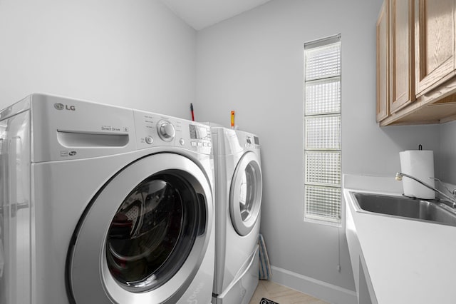550 SW Sanctuary Dr, Port Saint Lucie, FL 34986 - laundry room featuring cabinet space, washing machine and dryer, and baseboards