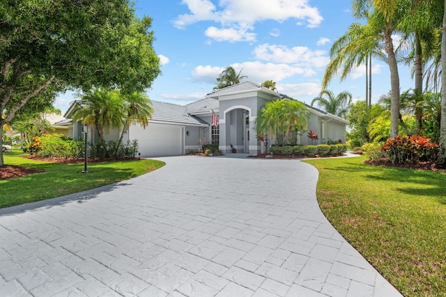 550 SW Sanctuary Dr, Port Saint Lucie, FL 34986 - view of front of property featuring curved driveway, an attached garage, a front yard, and stucco siding