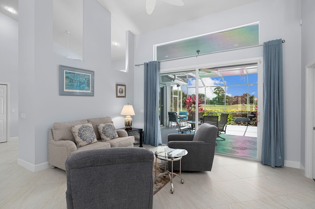 550 SW Sanctuary Dr, Port Saint Lucie, FL 34986 - living area with a towering ceiling, baseboards, ceiling fan, and a sunroom