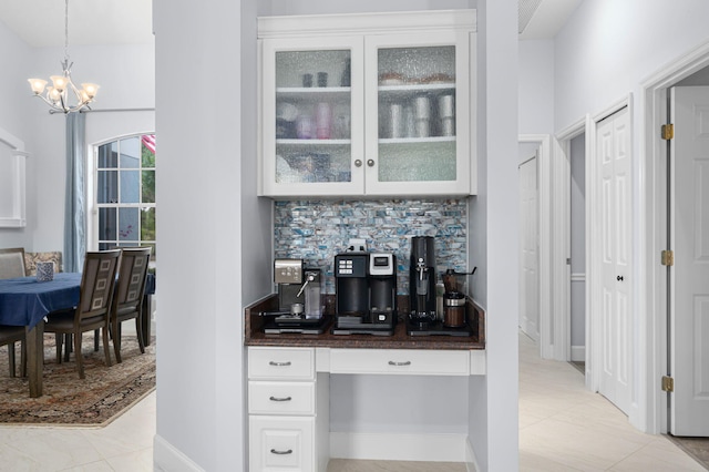 550 SW Sanctuary Dr, Port Saint Lucie, FL 34986 - bar featuring a chandelier, tasteful backsplash, pendant lighting, and light tile patterned flooring