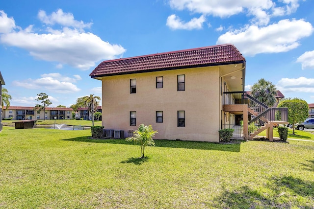 21895 Lake Forest Cir Unit 201, Boca Raton, FL 33433 - rear view of property featuring stairs, a yard, stucco siding, and a tiled roof