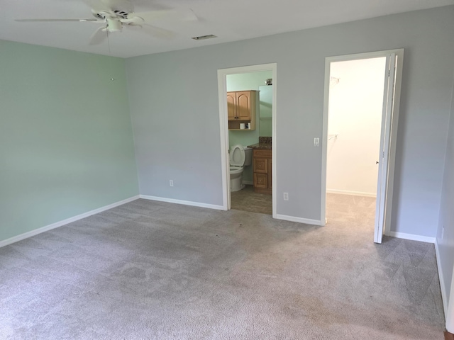 4365 SW Appleseed Rd, Port Saint Lucie, FL 34953 - unfurnished bedroom with carpet floors, baseboards, a walk in closet, connected bathroom, and ceiling fan