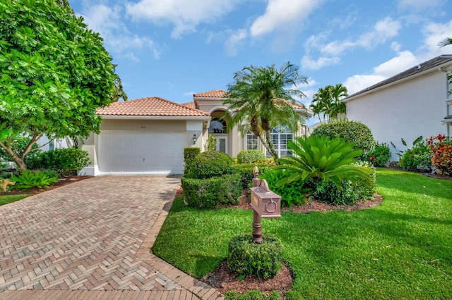 7919 L Aquila Way, Delray Beach, FL 33446 - mediterranean / spanish-style house with stucco siding, a front lawn, a garage, a tiled roof, and decorative driveway