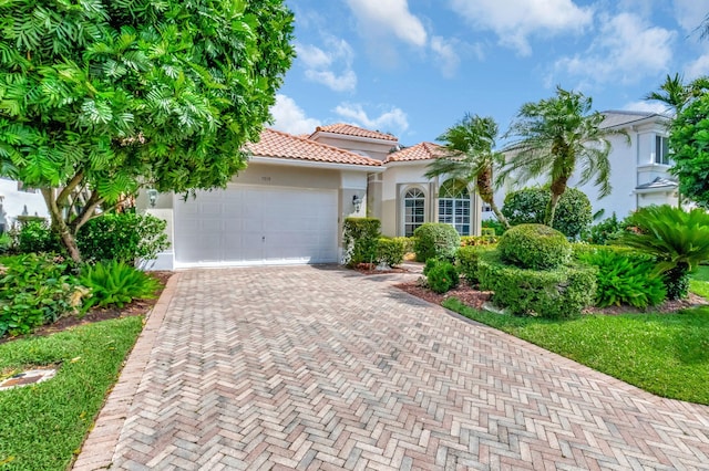 7919 L Aquila Way, Delray Beach, FL 33446 - mediterranean / spanish-style home featuring stucco siding, decorative driveway, a tile roof, and an attached garage