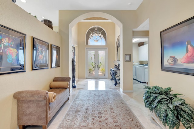 7919 L Aquila Way, Delray Beach, FL 33446 - entryway with washing machine and dryer, a chandelier, arched walkways, and french doors