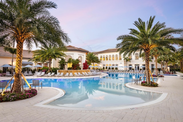 7919 L Aquila Way, Delray Beach, FL 33446 - pool at dusk featuring a community pool and a patio