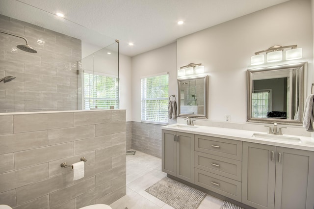 15048 85th Rd N, The Acreage, FL 33470 - bathroom featuring a walk in shower, double vanity, recessed lighting, tile patterned floors, and tile walls