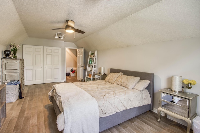 15048 85th Rd N, The Acreage, FL 33470 - bedroom featuring lofted ceiling, a closet, a textured ceiling, wood finished floors, and a ceiling fan