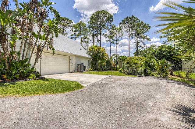 15048 85th Rd N, The Acreage, FL 33470 - view of property exterior featuring driveway, a garage, and central AC unit