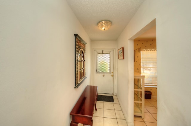 entryway with light tile patterned flooring and a textured ceiling