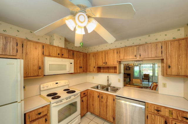 kitchen featuring white appliances, a sink, light countertops, ceiling fan, and wallpapered walls