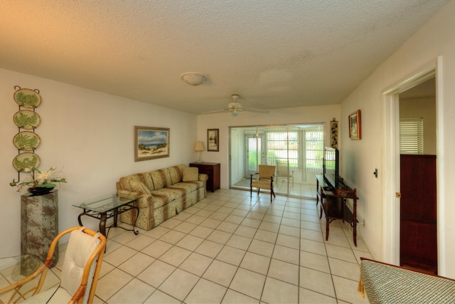 living area with light tile patterned flooring, a textured ceiling, and ceiling fan