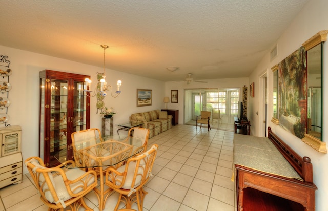 dining space with light tile patterned floors, a textured ceiling, a chandelier, and a ceiling fan