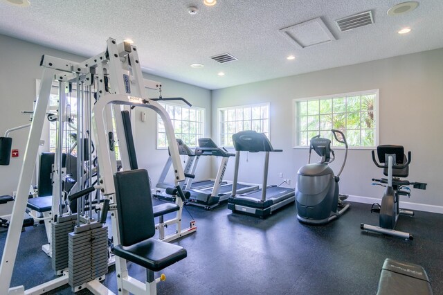 236 Village Blvd Unit 1303, Tequesta, FL 33469 - gym featuring healthy amount of natural light, a textured ceiling, recessed lighting, and baseboards