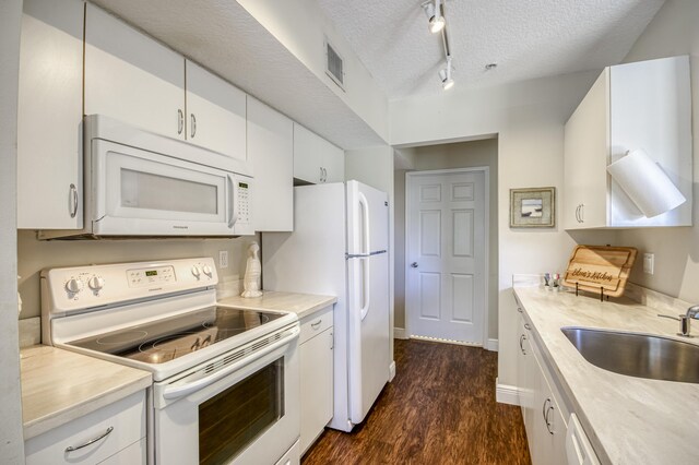 236 Village Blvd Unit 1303, Tequesta, FL 33469 - kitchen with white appliances, a textured ceiling, dark wood-type flooring, light countertops, and white cabinetry
