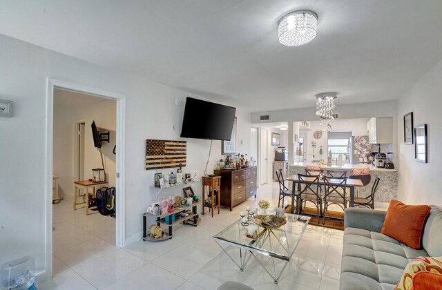 130 Lake Meryl Dr Unit 226, West Palm Beach, FL 33411 - living room featuring a chandelier, light tile patterned floors, and baseboards