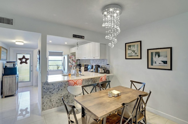 130 Lake Meryl Dr Unit 226, West Palm Beach, FL 33411 - dining space with light tile patterned floors, a chandelier, and baseboards