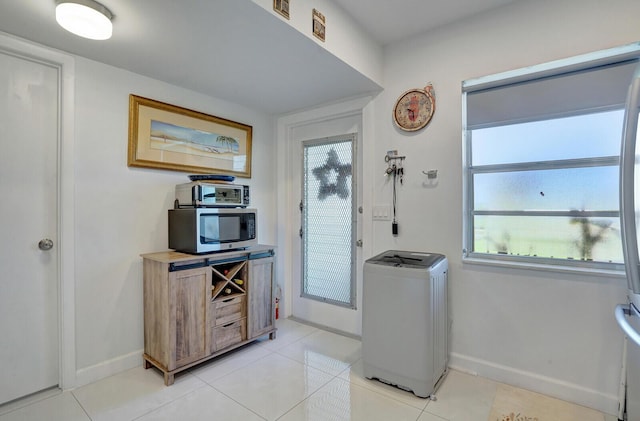 130 Lake Meryl Dr Unit 226, West Palm Beach, FL 33411 - foyer featuring washer / dryer, baseboards, and light tile patterned floors