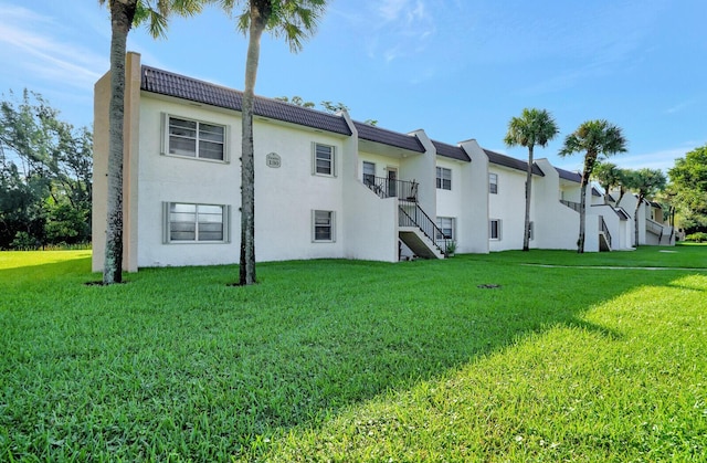 130 Lake Meryl Dr Unit 226, West Palm Beach, FL 33411 - back of property with stairway, a yard, and stucco siding