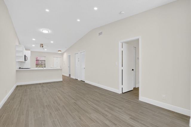 8583 Overset Ln Unit C, Boca Raton, FL 33496 - unfurnished living room featuring wood finished floors, vaulted ceiling, and recessed lighting